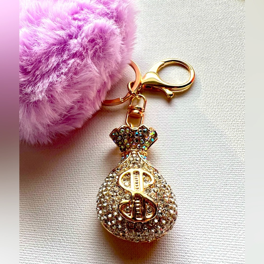 Llavero (Keychain) con pompón en forma de corazón y saco del dinero.